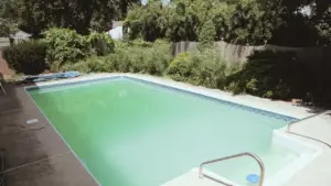 Residential swimming pool with green algae water